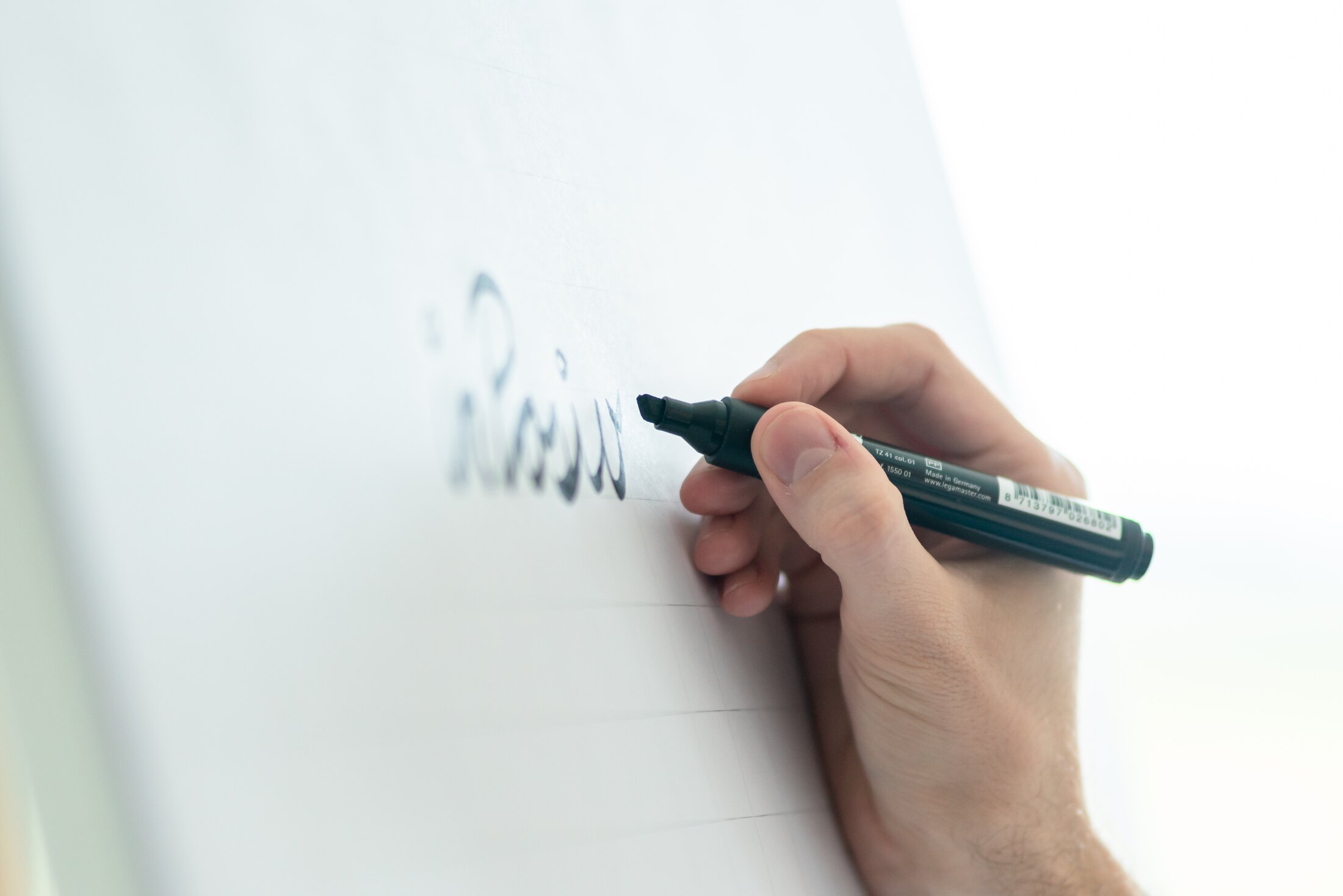 Eine Hand, die einen Automatisierungs-Workflow auf einem Whiteboard schreibt