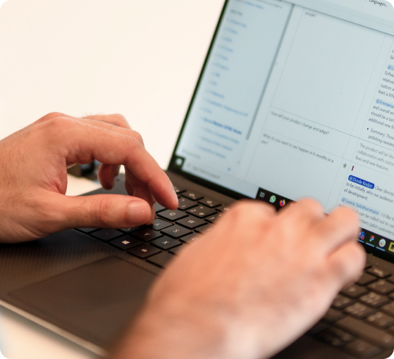 Hände, die an einem KI-Strategie-Dokument auf einem Laptop arbeiten