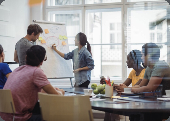 Ein Team, das Prioritäten um ein Whiteboard bespricht